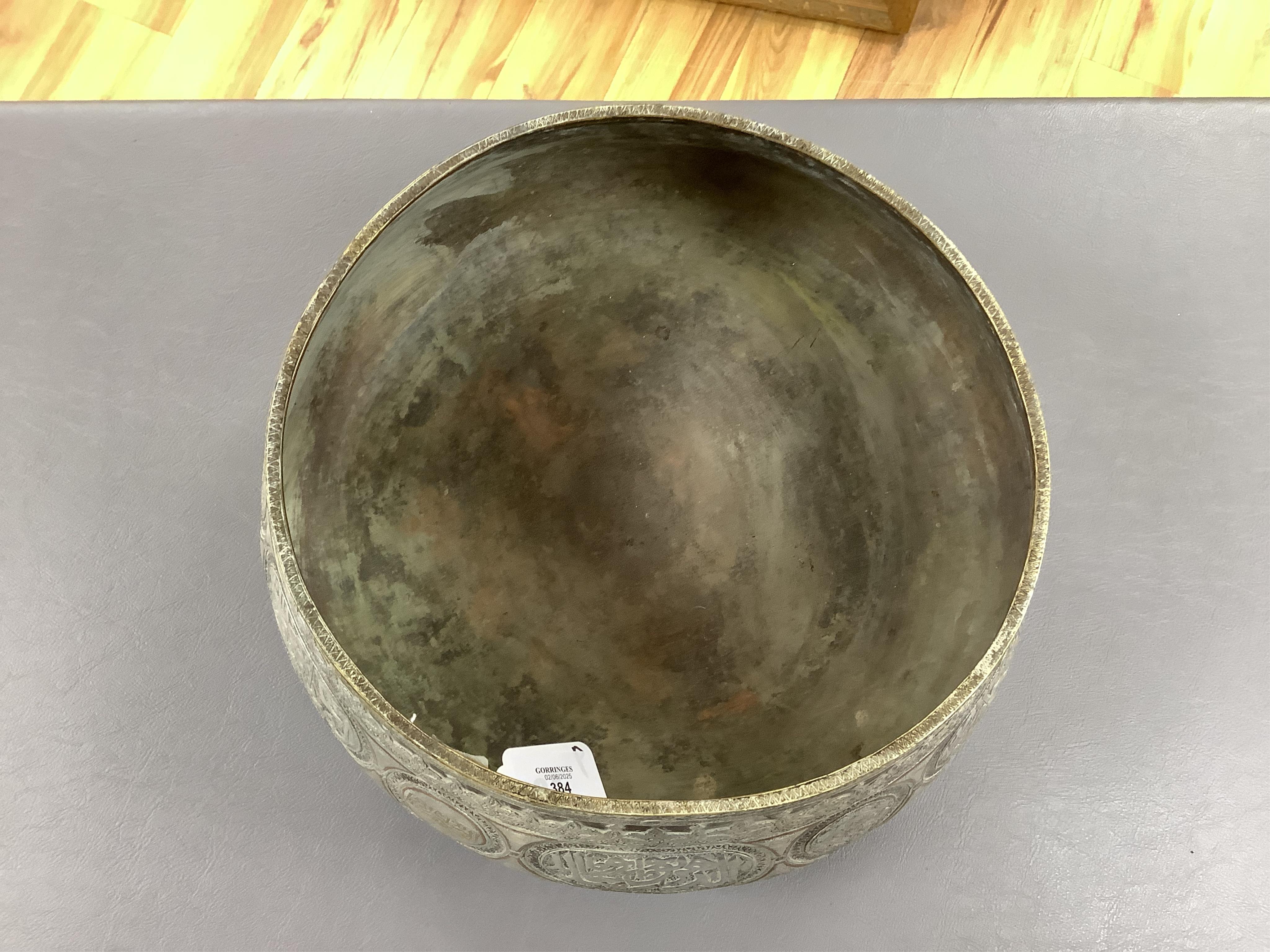 A late 19th century Mamluk style brass basin inlaid with silver and copper decoration, 29cm diameter